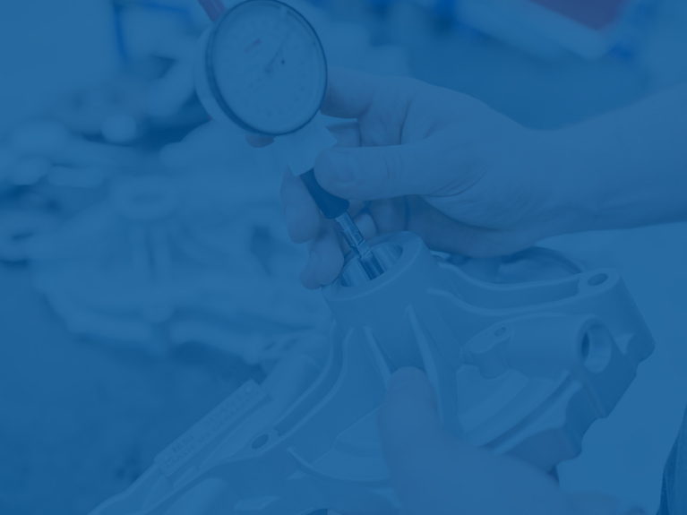 Крупним планом рука, яка перевіряє запчастину за допомогою вимірювального приладу