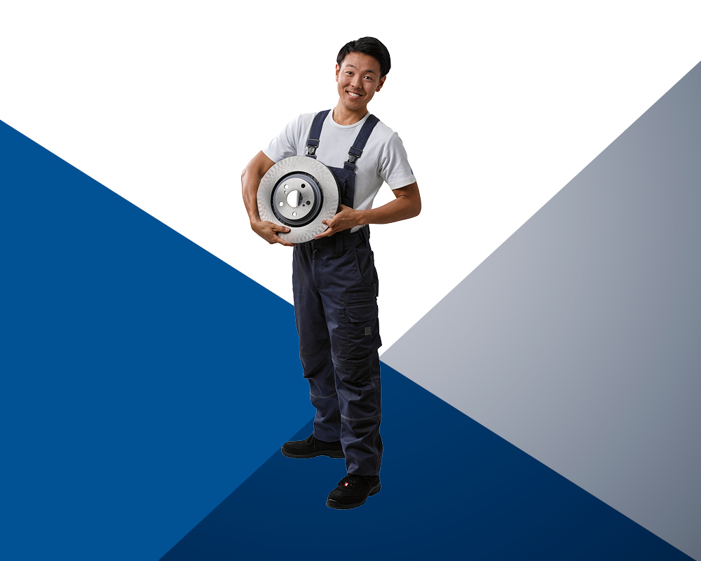 Автомеханік тримає у руках гальмівний диск